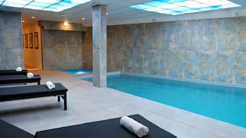 Relax by the pool surrounded by comfortable lounge chairs and a modern ceiling design.