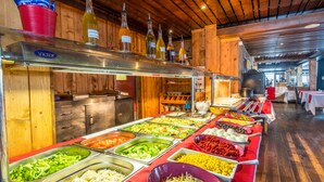 Un bufé con diversas opciones de comida y botellas de vino.