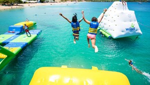 A clear turquoise sea with inflatable water toys and a person in the water. - Bay Gardens Inn (Gros Islet)