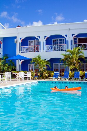 Een buitenzwembad, parasols voor strand/zwembad
