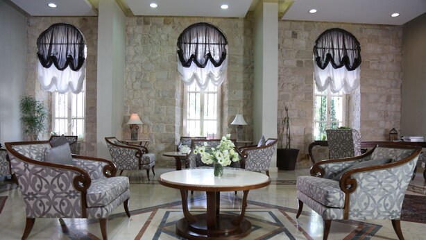 A spacious lobby with a round marble table, patterned armchairs, and large windows with sheer curtains. - Grand Kadri Hotel (Zahlé)