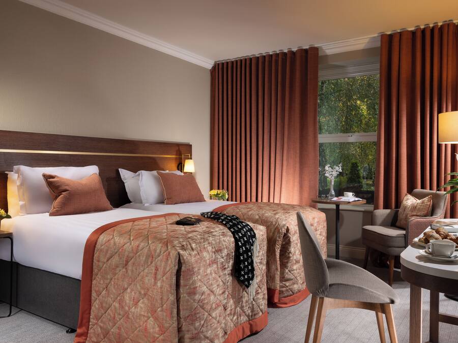 Una habitación de hotel con una cama grande, un escritorio y una mesa de comedor.