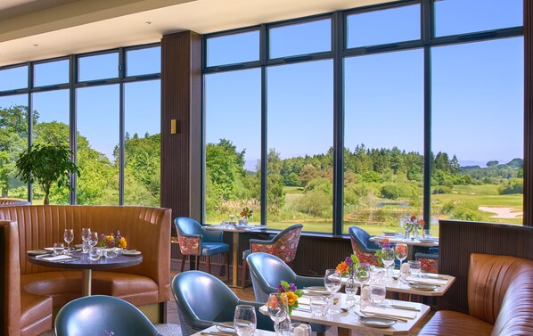 Enjoy a formal dining experience with a scenic view of lush greenery from the comfort of a stylish dining area.