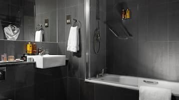 A modern bathroom with a glass-enclosed shower, a bathtub, and a sink.