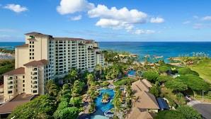 A resort with multiple buildings, a swimming pool, and a view of the ocean.
