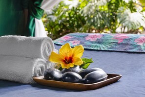 Experience relaxation in our serene spa setting, complete with a clean towel, soothing stones, and a touch of nature.