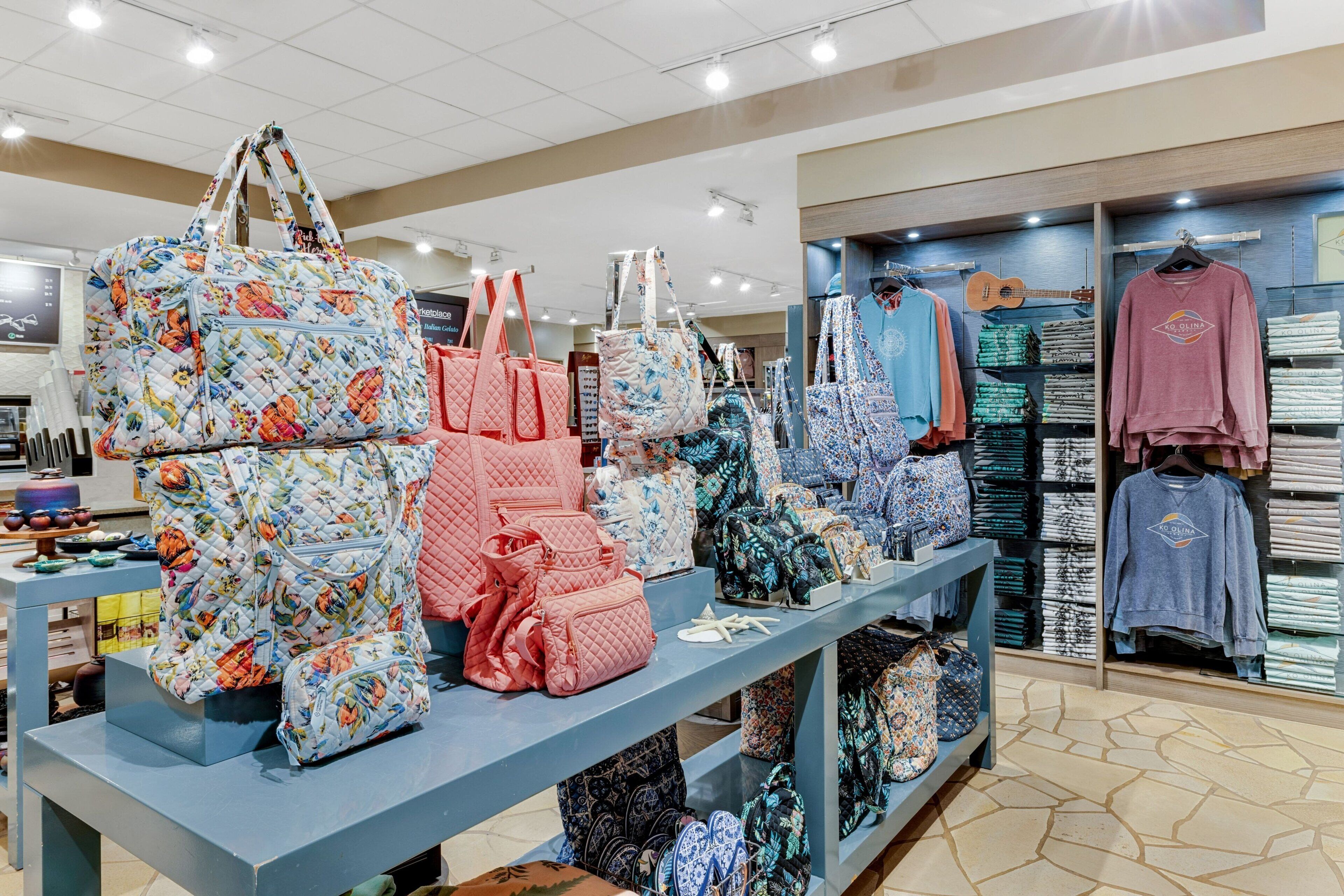 Un magasin de détail où sont exposés divers modèles de sacs et de vêtements.