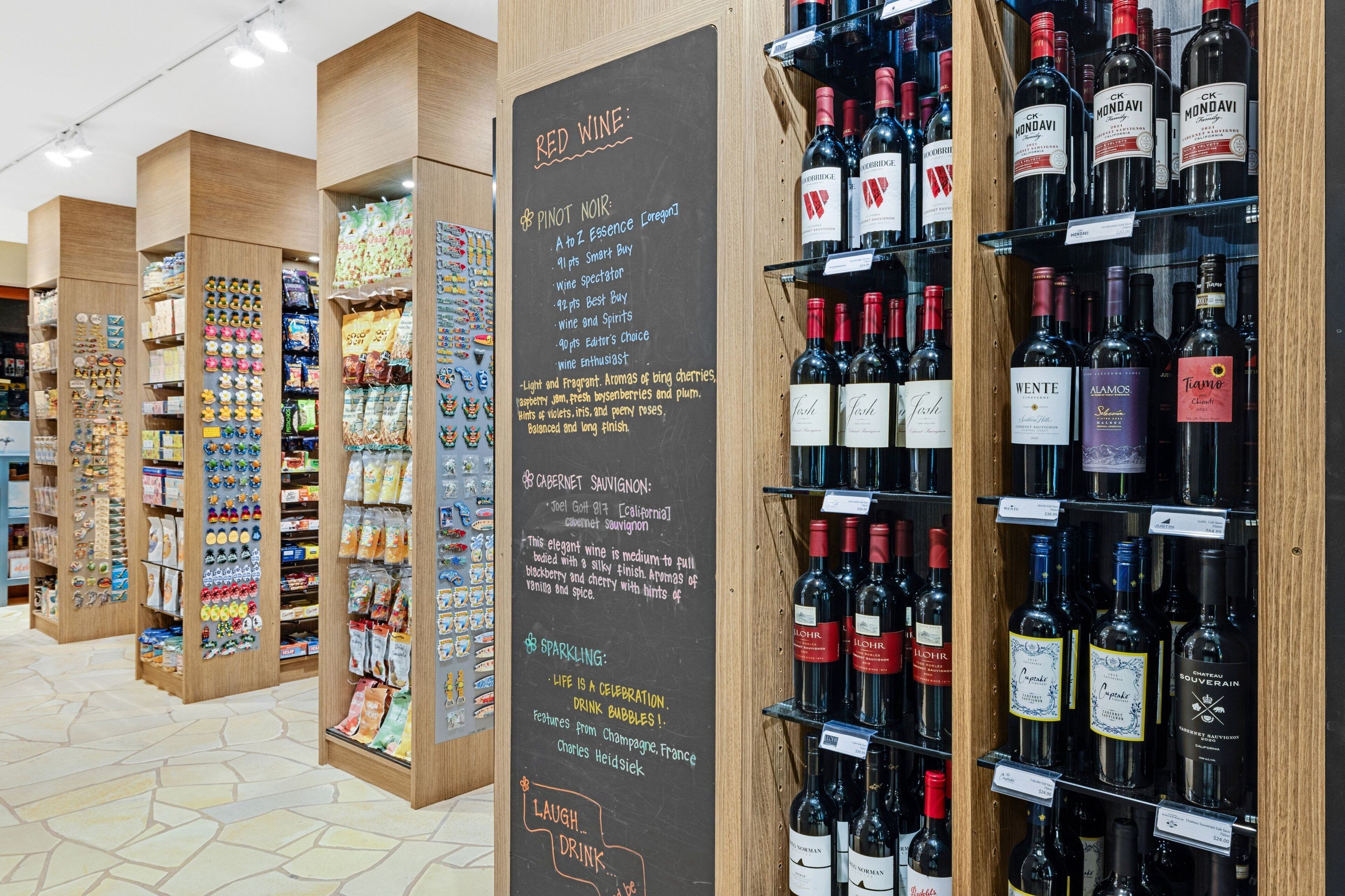 Una tienda de vinos con estantes llenos de vino tinto y espumoso.