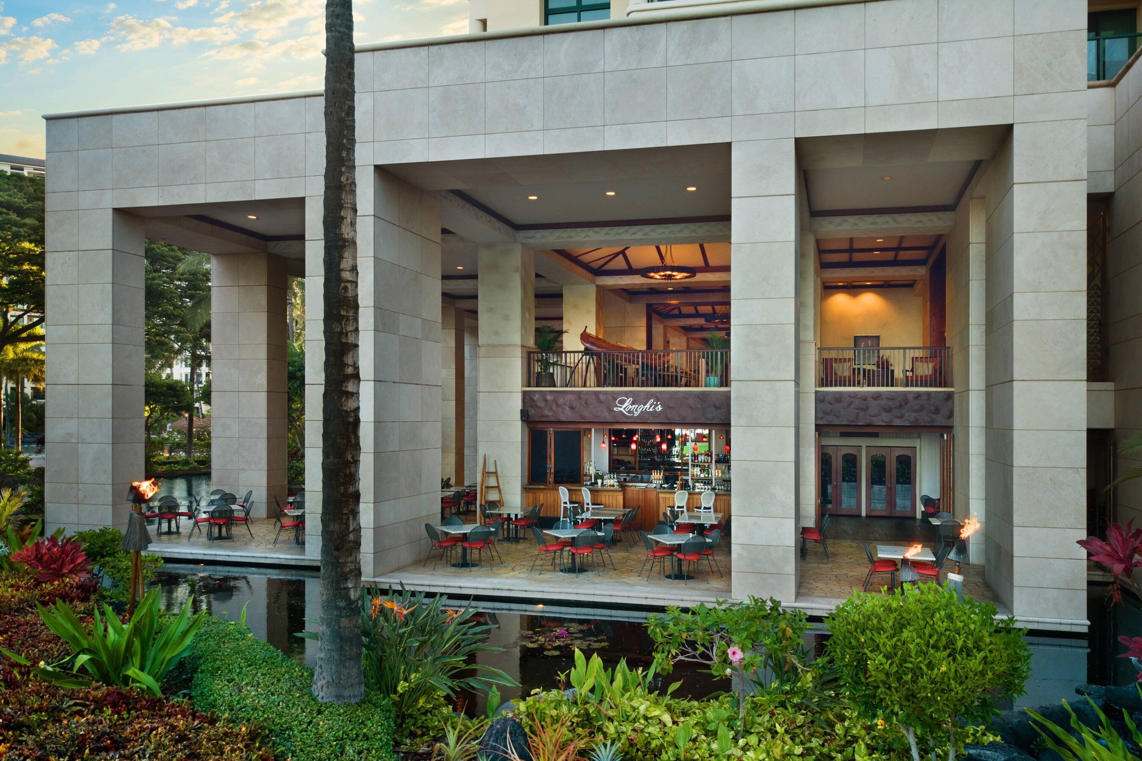 A modern hotel with a bar/lounge area, outdoor seating, and a pool.