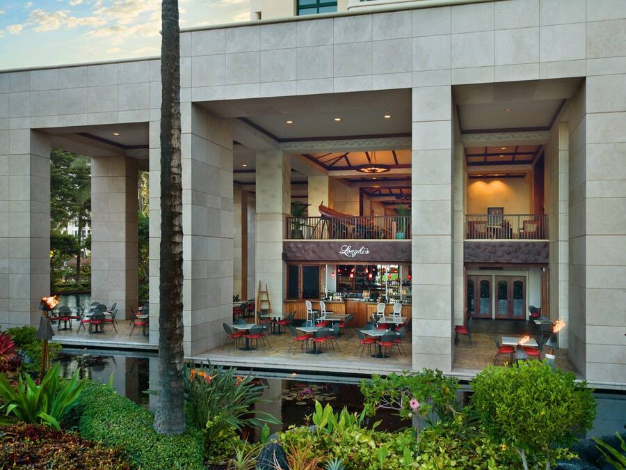 A modern hotel with a bar/lounge area, outdoor seating, and a pool.