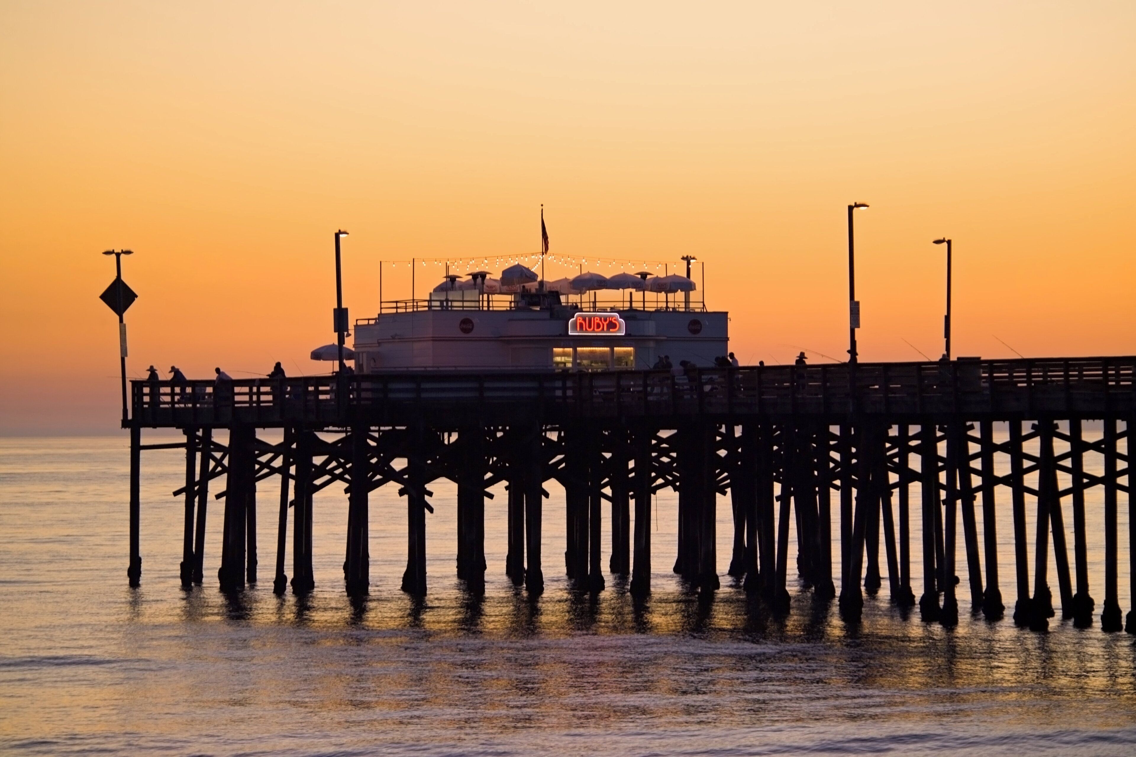 A pier extending into the water with a boat docked at the end.