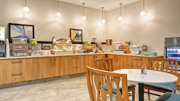 Un espace dédié au petit-déjeuner, comprenant un comptoir, des places assises et divers aliments.