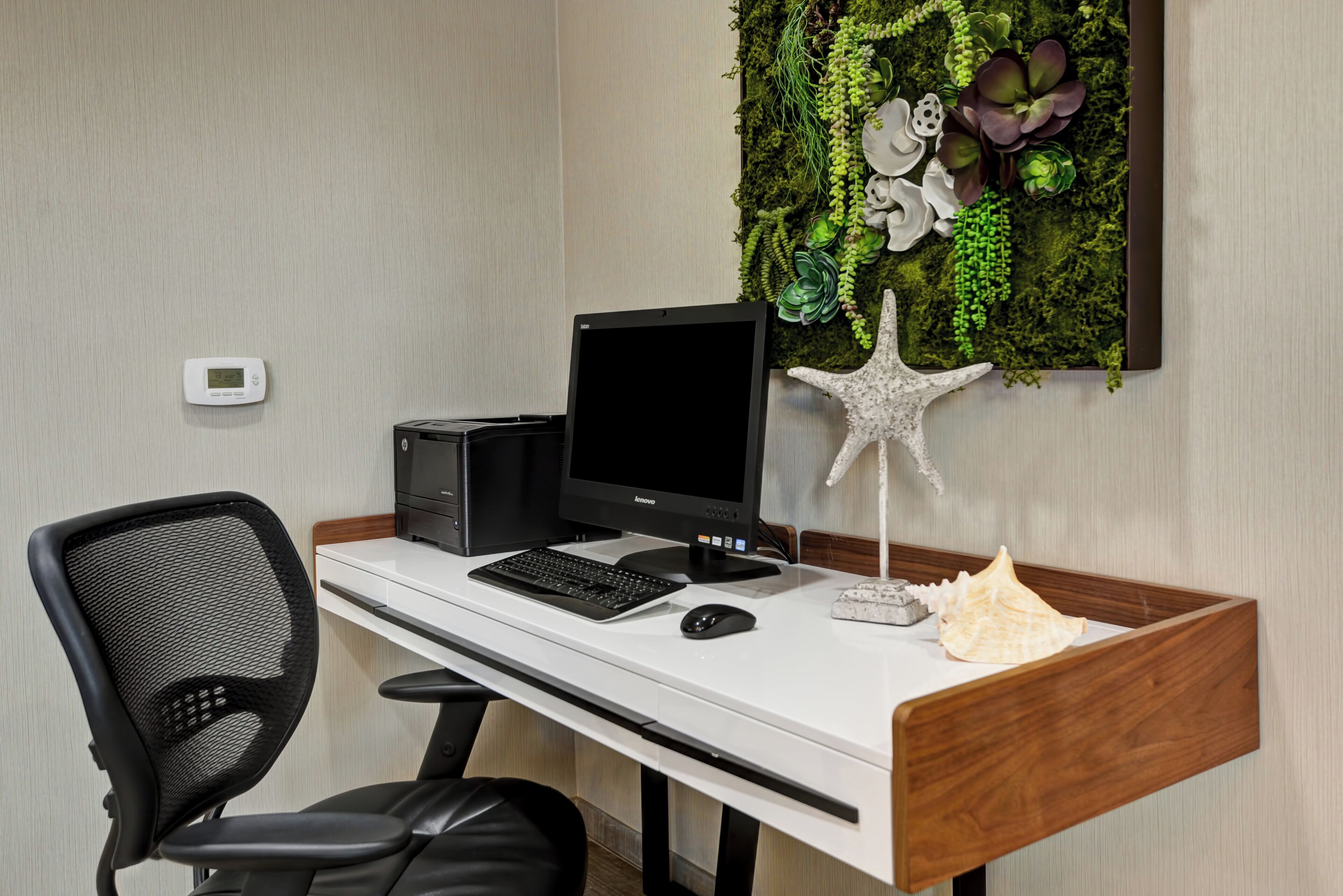 A modern office setup with a desktop computer, keyboard, mouse, and a chair.