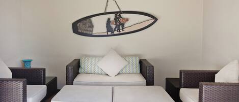 Una habitación con un conjunto de sofás, una obra de arte colgada y un pequeño jarrón decorativo.