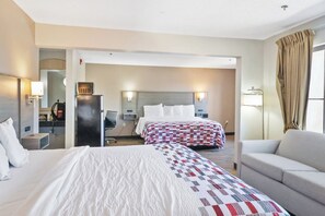 A hotel room with a large bed, a sofa, a desk, and a mirror. - Red Roof Inn & Suites Fayetteville - Fort Bragg (Fayetteville)