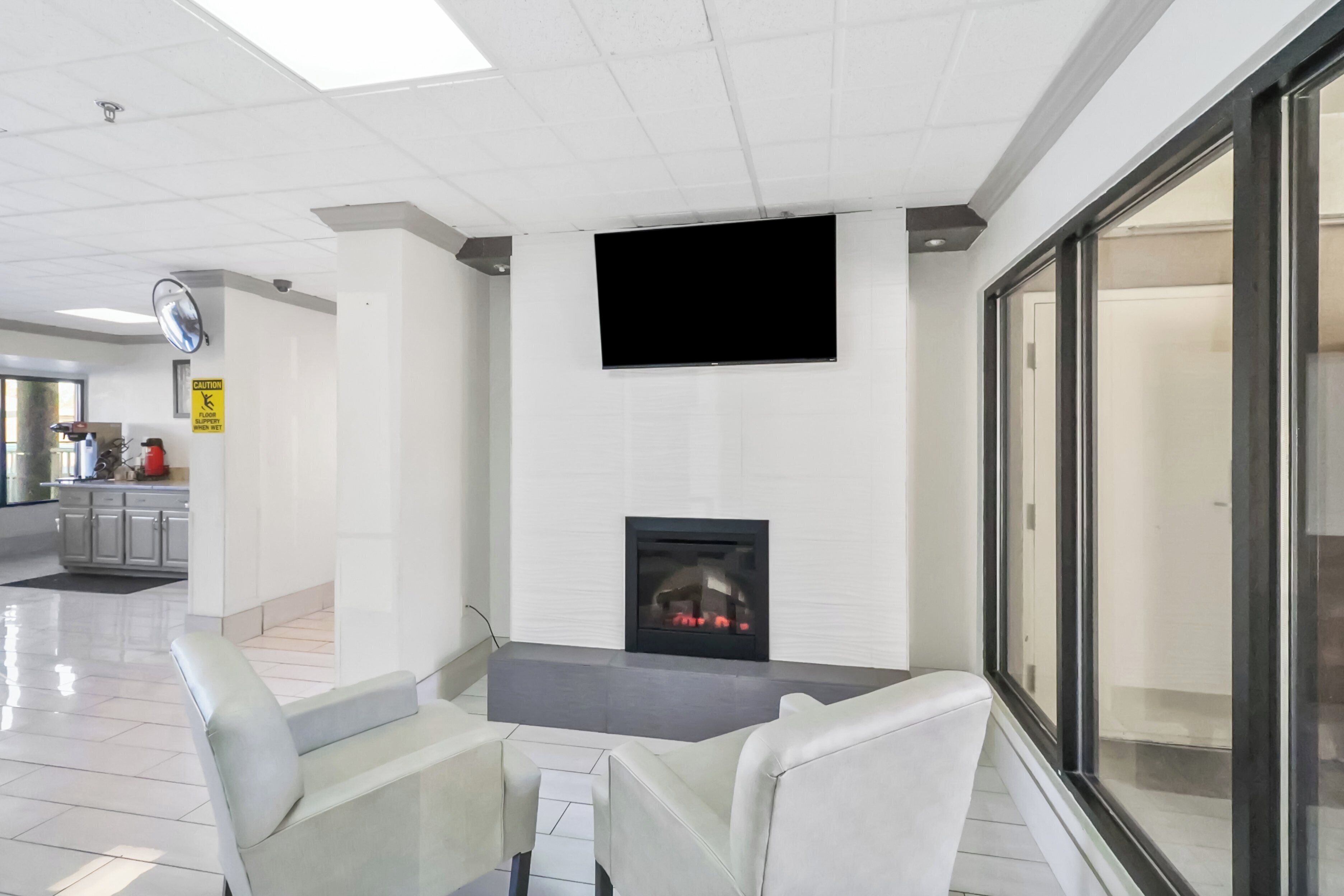 Un interior moderno con chimenea, televisor de pantalla plana y una zona de estar con sillones.