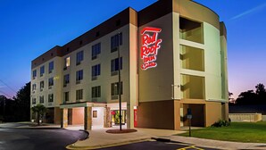 A Red Roof Inn hotel with a modern design, multiple floors, and a Coca-Cola sign. - Red Roof Inn & Suites Fayetteville - Fort Bragg (Fayetteville)