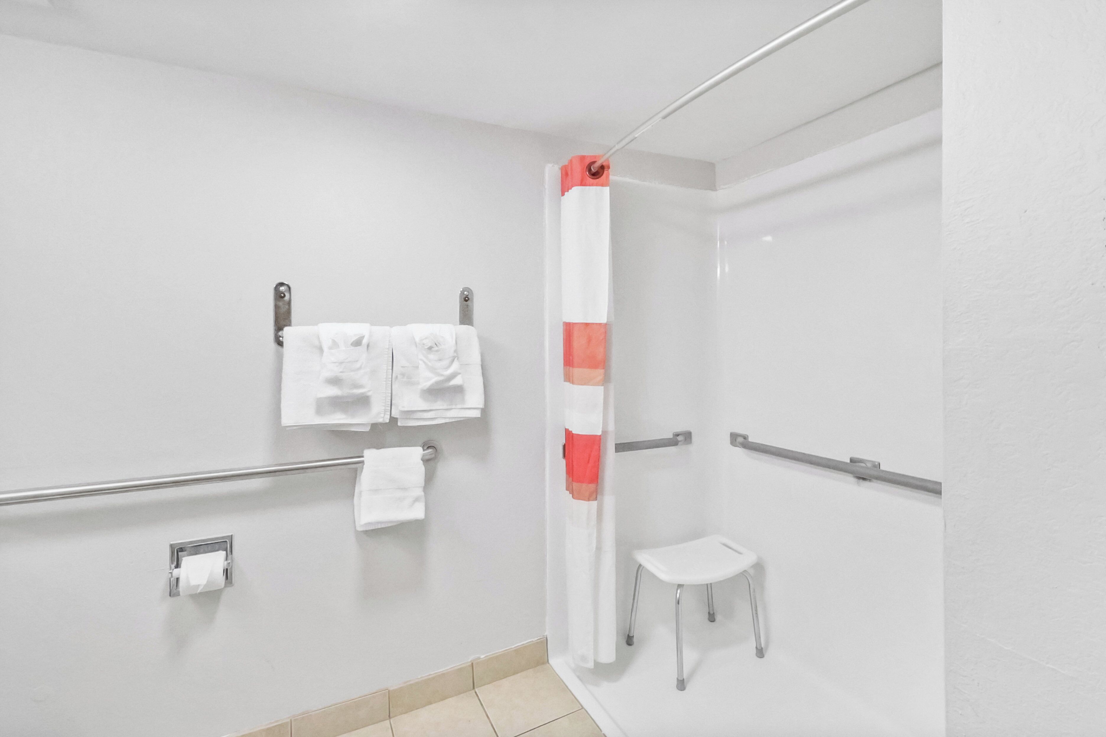 Une salle de bain avec une douche, des toilettes et un petit tabouret.