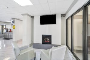 Un interior moderno con chimenea, zona de estar y televisor de pantalla plana montado en la pared.