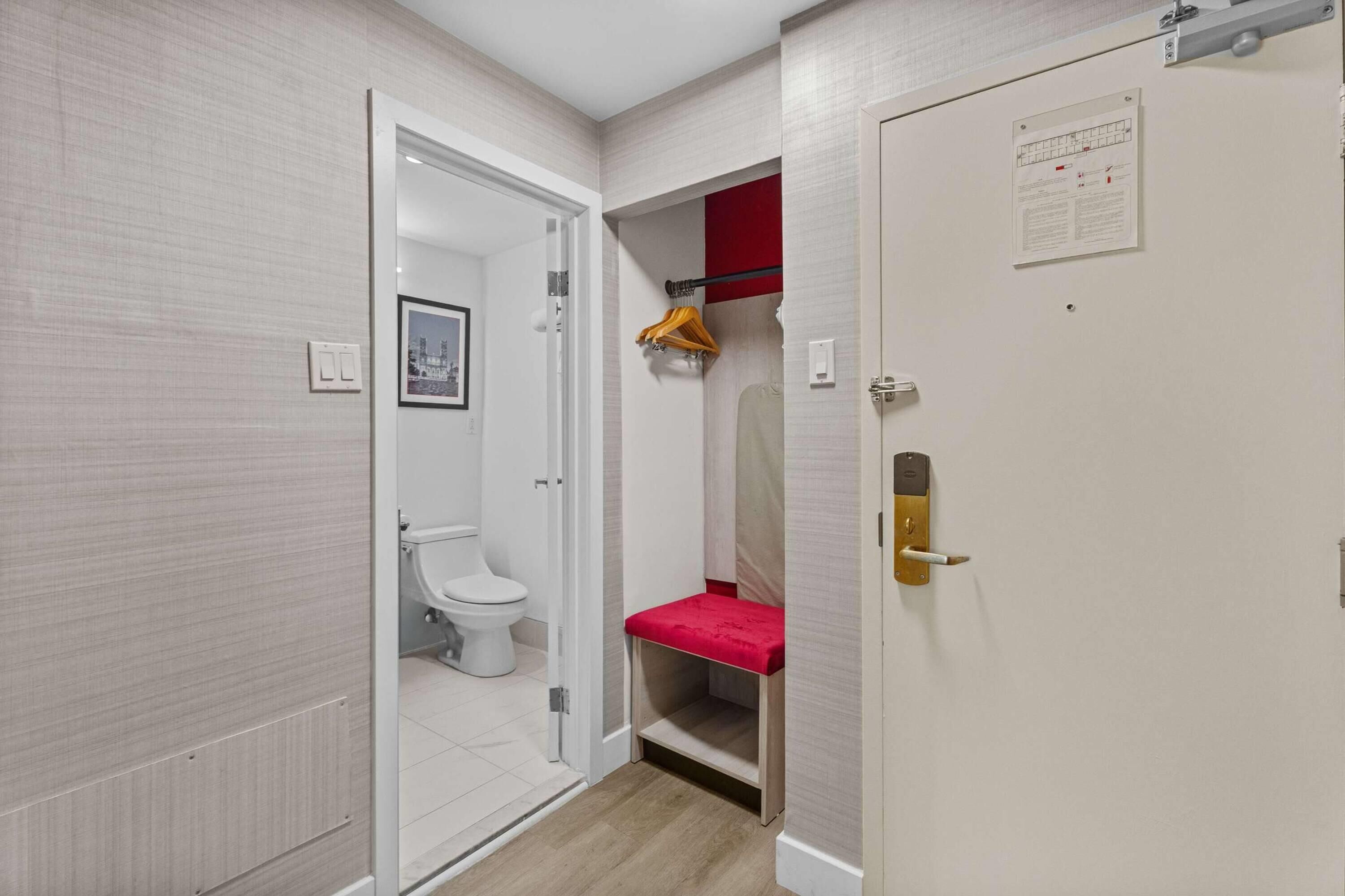 Un baño con inodoro, zona de ducha y puerta con cerradura.
