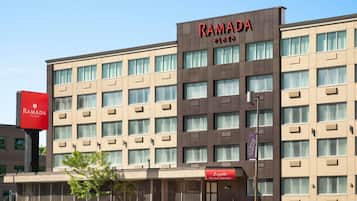 A multi-story building with a sign reading 'RAMADA PLAZA' and a restaurant named 'Luzzatto Fine Cuisine'.