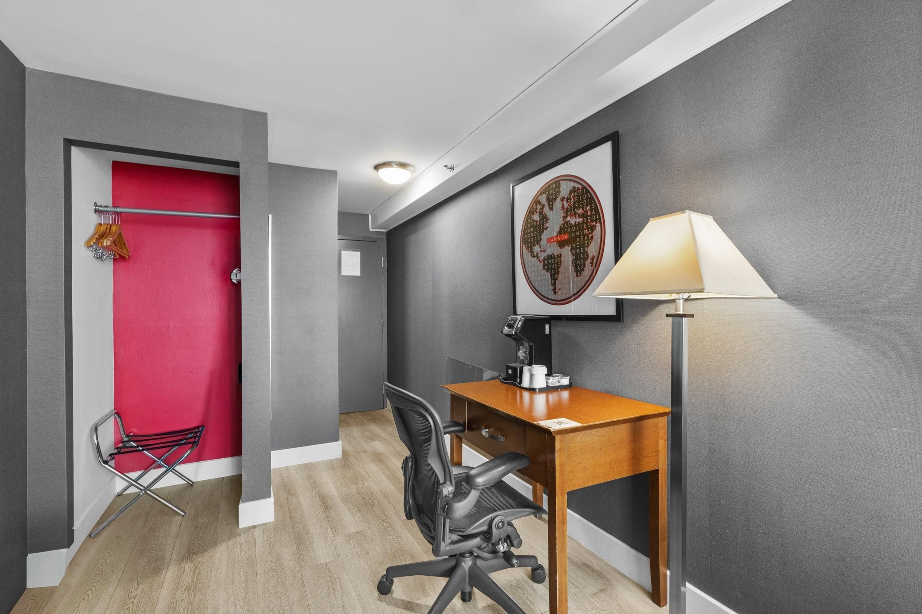 A modern office space with a desk, chair, and a red door.