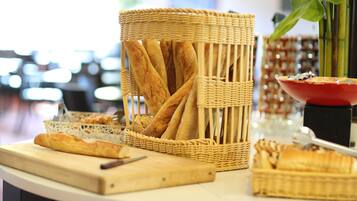 A table with baskets of bread and a cutting board.