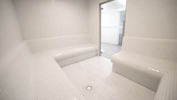 Relax in a spacious bathtub against a grid-patterned floor.