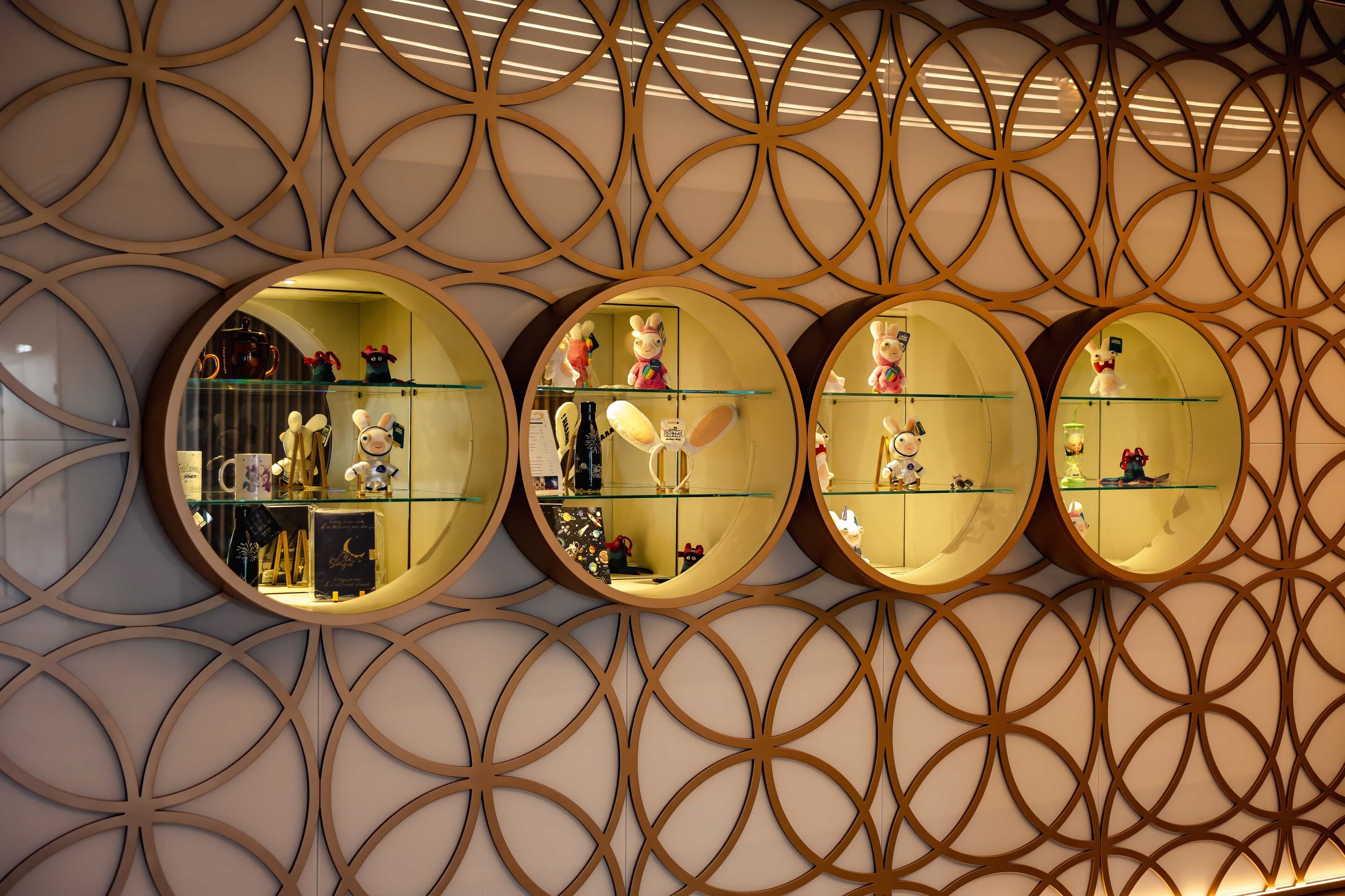 A wall with circular mirrors and shelves displaying various items.