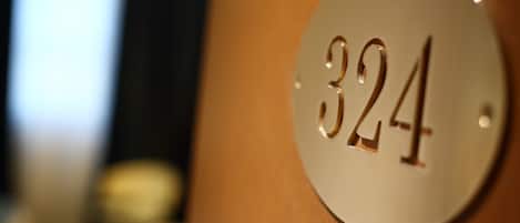 A close-up of a metallic number plate with the number 324.