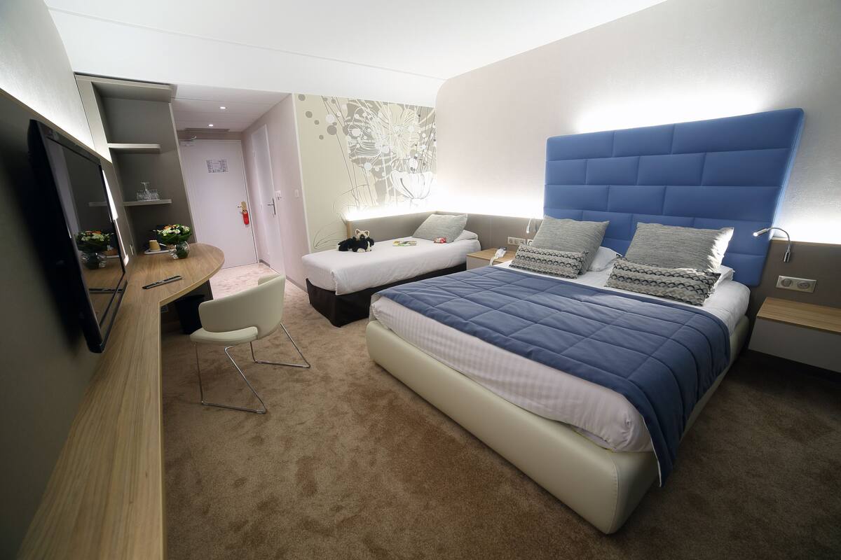 Ein modernes Hotelzimmer mit einem großen Bett, einem Schreibtisch und einem Sessel.