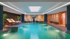 A swimming pool with lounge chairs and a skylight. - Le Méridien Hamburg (Hamburg)