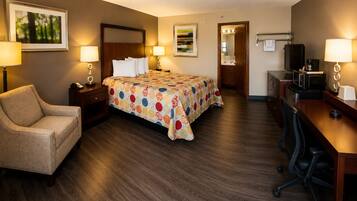 Une chambre d’hôtel avec un lit, un bureau, une chaise et un téléviseur.