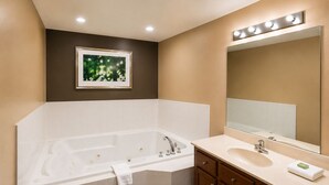 A bathroom with a bathtub, vanity, mirror, and recessed lighting. - Colonial Inn (Camden)