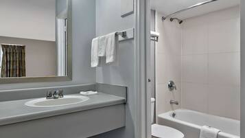 A modern bathroom with a sink, mirror, and toilet.