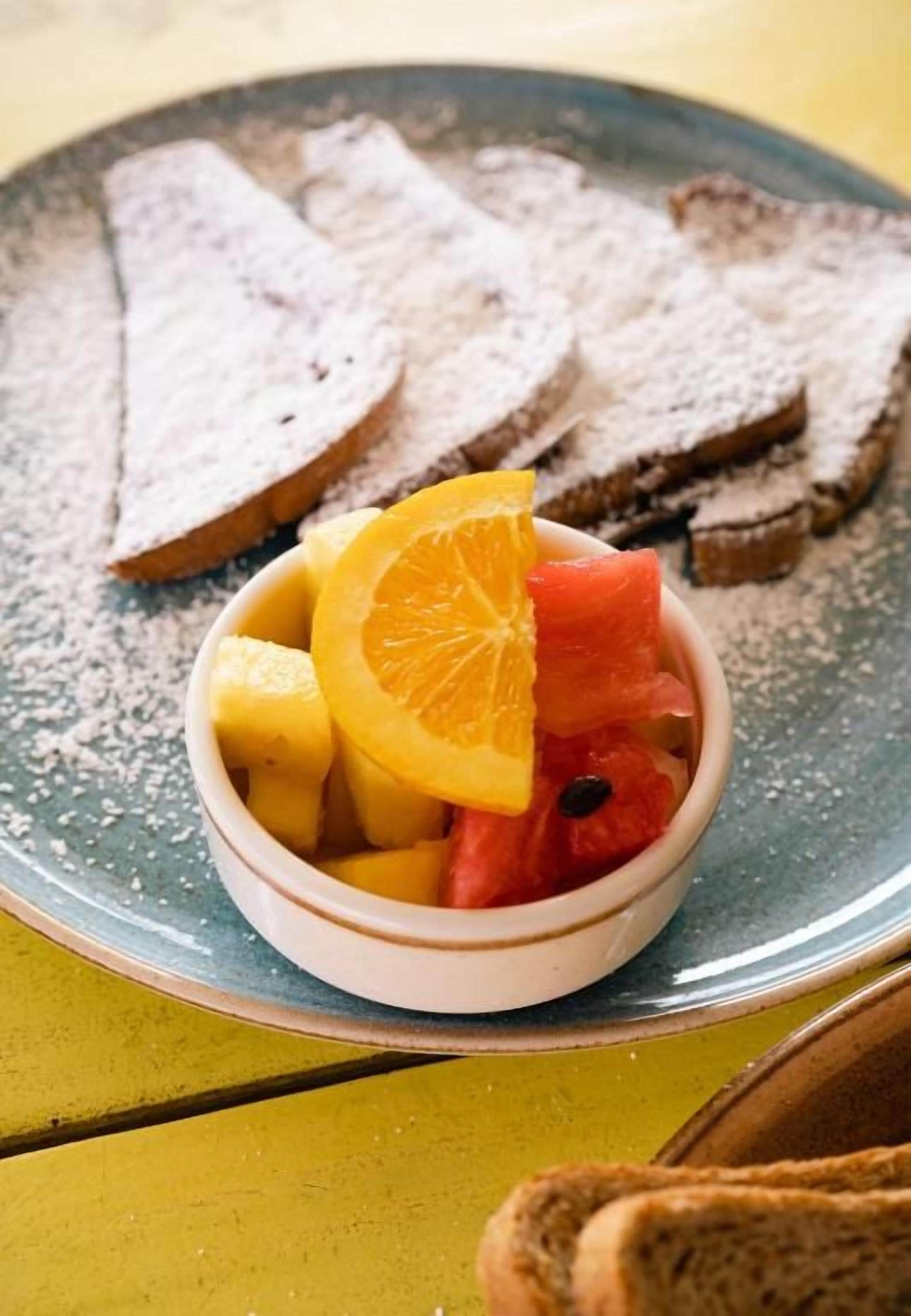 Un plato con rebanadas de pan y un bol de fruta.