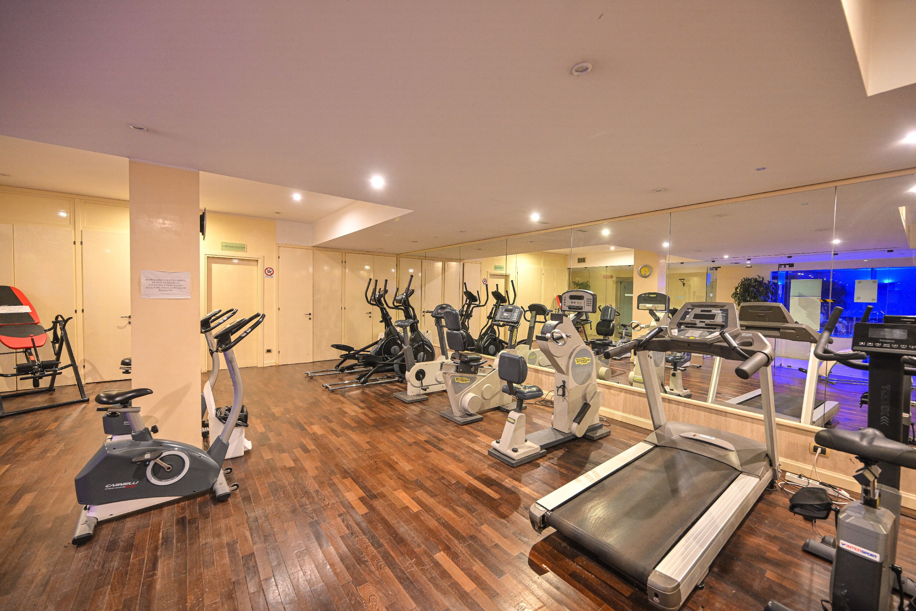 A gym with various exercise equipment, including treadmills and stationary bikes.