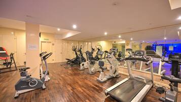 A gym with various exercise equipment, including treadmills and stationary bikes.