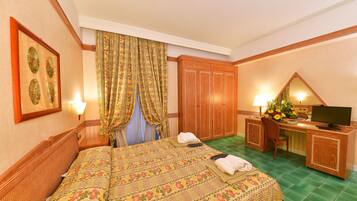 A hotel room with a bed, desk, chair, and a television.