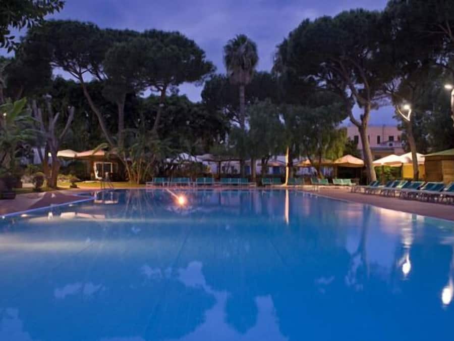 Een binnenzwembad, een buitenzwembad, ligstoelen bij het zwembad