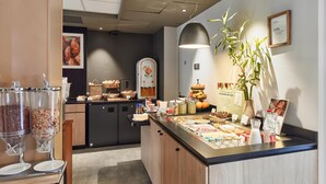 A breakfast bar with various food items and a coffee machine. - Campanile PRIME - Paris 15 Tour Eiffel (Paris)