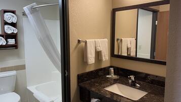Un baño con ducha, inodoro, lavabo y perchero para toallas.