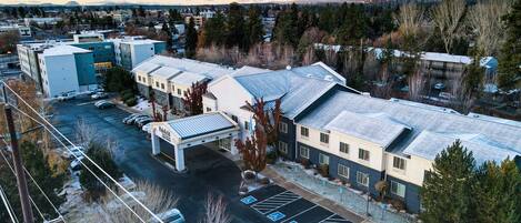 A multi-story building with a parking lot and a covered walkway.