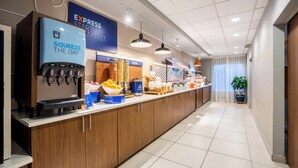 A hotel breakfast area with a self-serve coffee station, cereal display, and a variety of food options. - Holiday Inn Express & Suites Orange City - Deltona by IHG (Orange City)