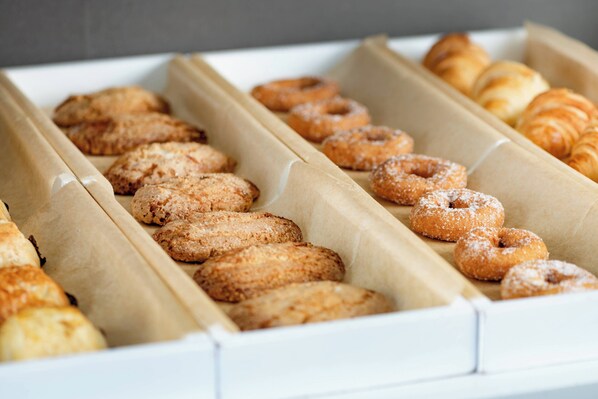 A box of assorted pastries including croissants and donuts. - AC Hotel Badajoz by Marriott (Badajoz)
