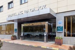 The exterior of a hotel with a prominent entrance, glass doors, and a sign indicating it is part of the AC Hotels Marriott chain. - AC Hotel Badajoz by Marriott (Badajoz)