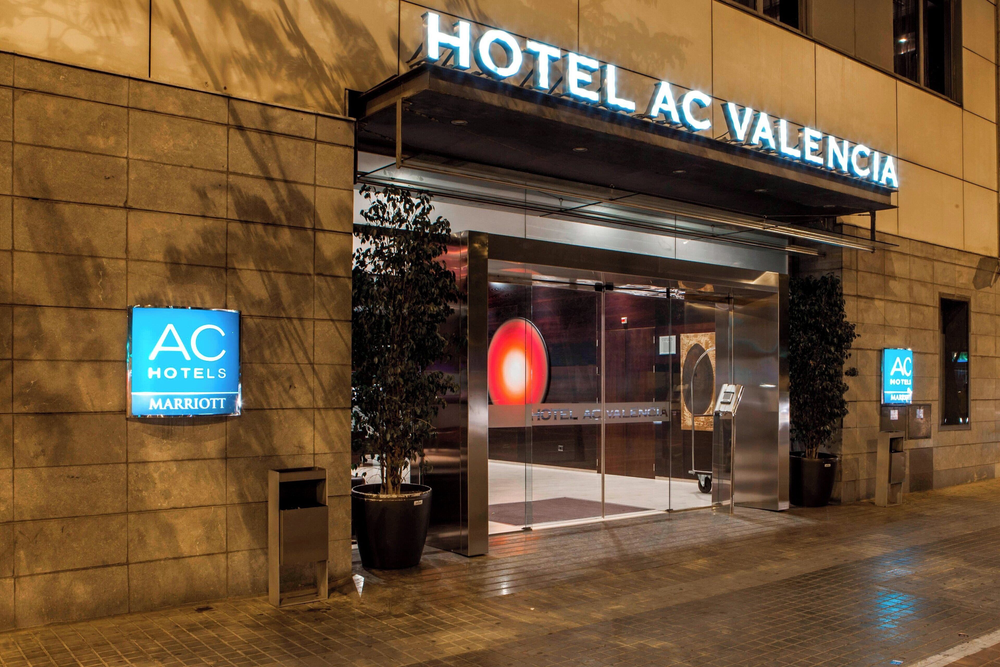 The exterior of Hotel AC Valencia, featuring a modern facade, large glass entrance, and prominent signage.