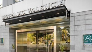 L’extérieur de l’hôtel Valencia se distingue par sa façade moderne, son grand hall d’entrée vitré et les plantes en pot qui décorent l’entrée.
