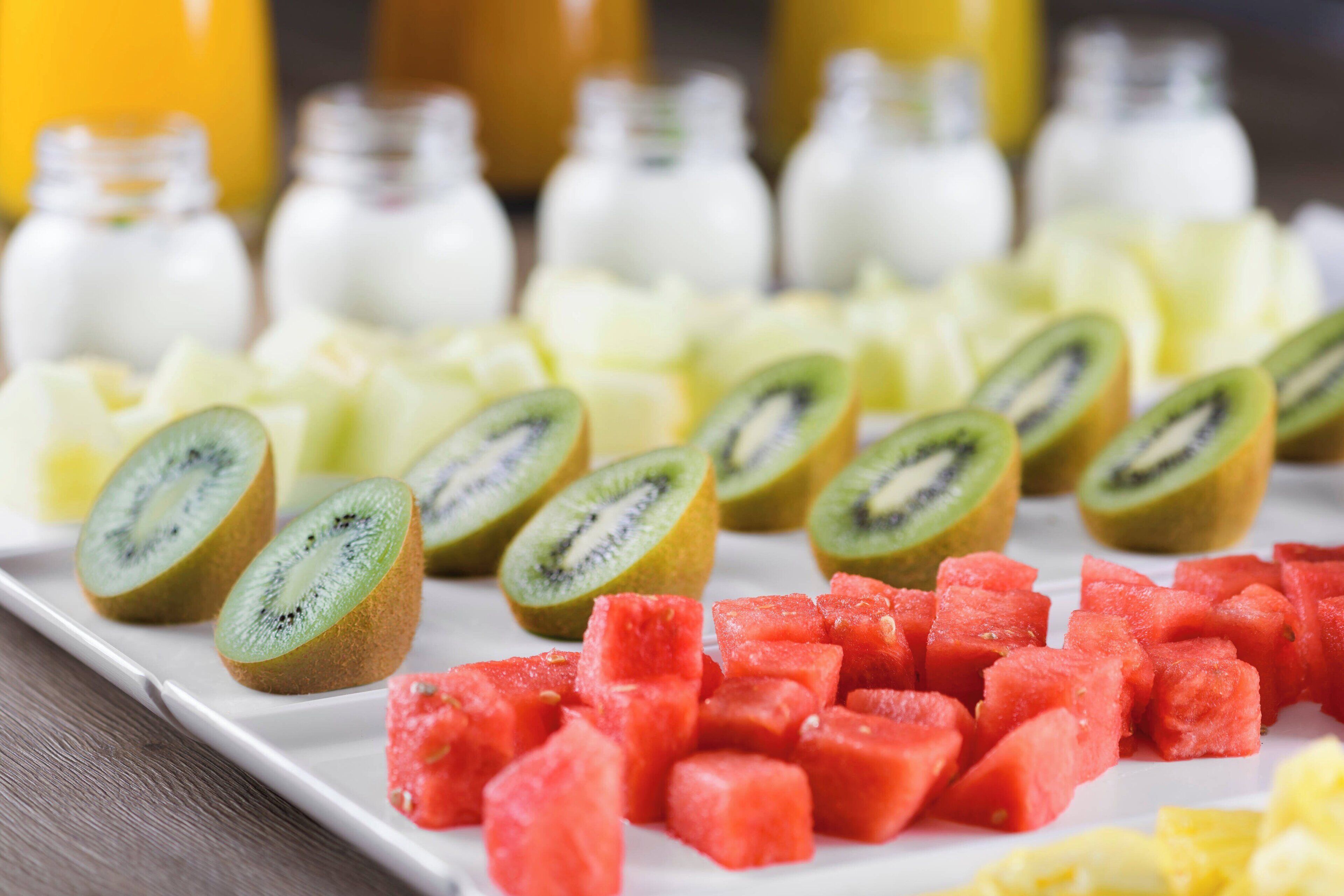 Un piatto con kiwi a fette, anguria e altra frutta.