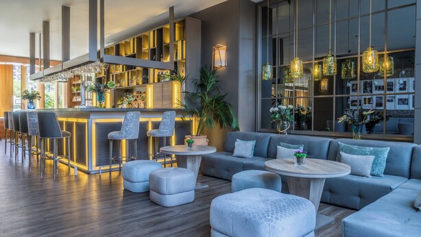 Un espace bar moderne, doté de sièges et d’un comptoir.